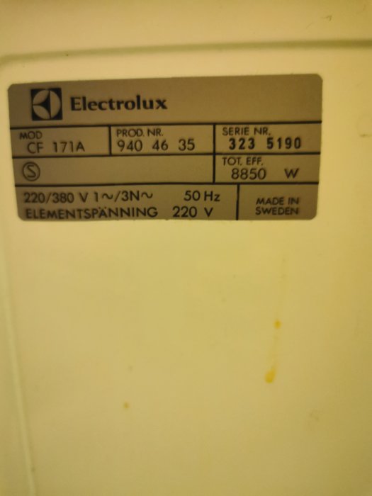 Typskylt på en Electrolux-spis med modellnummer, serienummer och specifikationer.