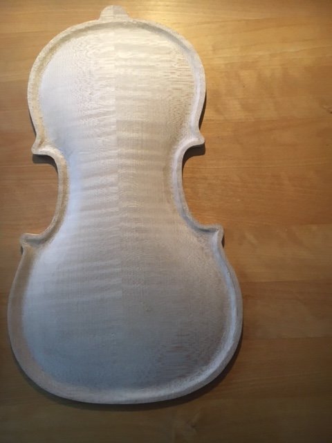 Obehandlad träfiolskropp på ett bord, formad som en Stradivarius 1720, med synliga verktygsspår.