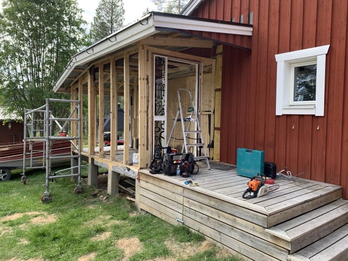 Renovering av husets hall under konstruktion, med synliga trästommar och byggverktyg på trädäcket.