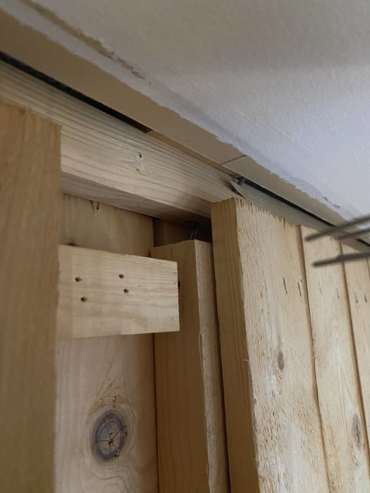 Väggkonstruktion med stående råspont och 34x34 reglar, övre regel ej fäst i råspont.