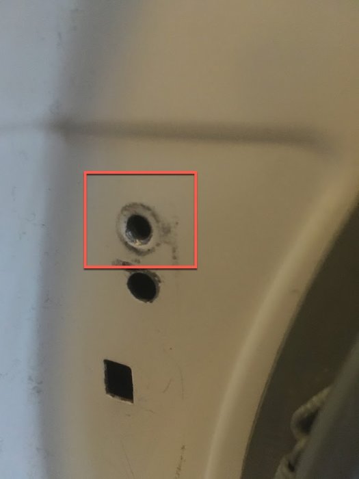 Närbild på en trasig gänga där skruven hoppat ur en Bosch tvättmaskin från 2012.