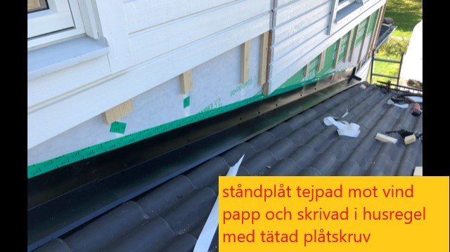 Byggarbetsplats där ståndplåt tejpats mot vindpapp och skruvats fast i husregel med täta skruvar.