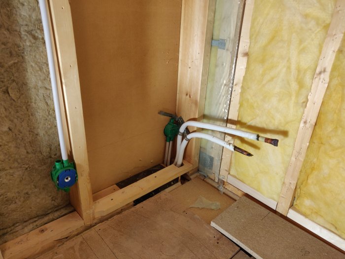 Väggskiva med urjackning och rörinstallation, inklusive dosa och vinkelplåt i hörnet.