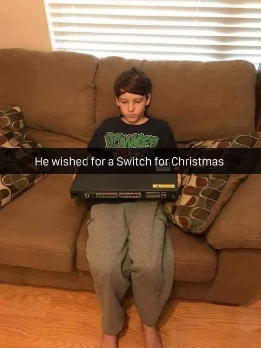 Pojke sitter på en soffa med en stängd nätverksswitch på sitt knä och text som säger "He wished for a Switch for Christmas".