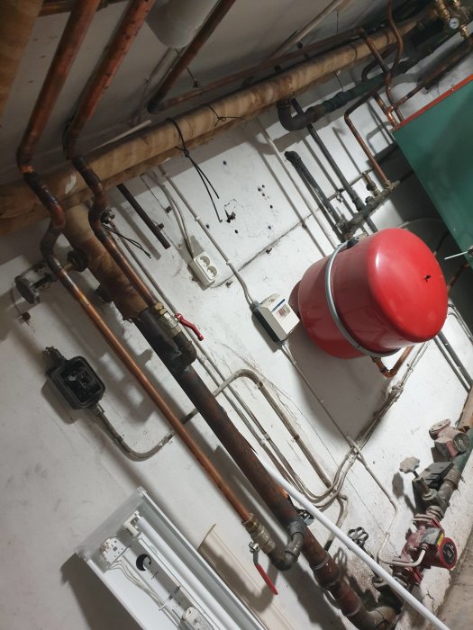 Värmesystem i källare med pump, rörledningar, expansionskärl och cirkulationspump.