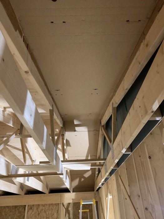 Delvis konstruerad luftspalt i garagetak med synlig takläkt och isoleringsmaterial mellan reglarna.