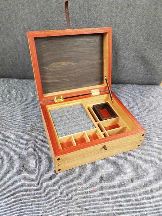 Handgjort smyckeskrin i träslagen ek, svartek och paduk med detaljer i mässing och läder.