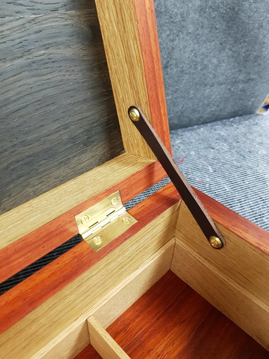 Handgjort smyckeskrin i ek, svartek och paduk med mässingsdetaljer och läderrem.