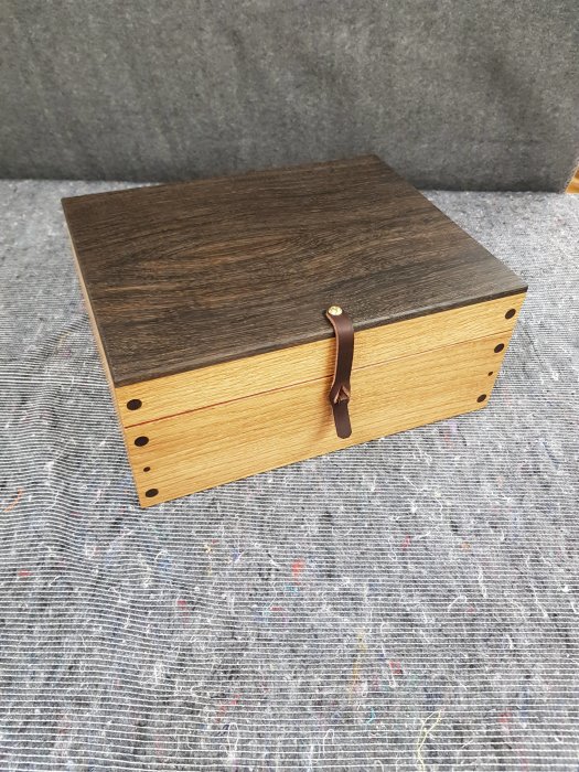 Handgjort smyckeskrin i ek, svartek och paduk med mässingsdetaljer och läderhandtag.