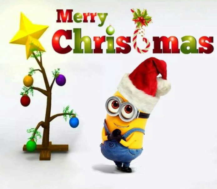 Minion i tomteluva bredvid julgran och texten "Merry Christmas