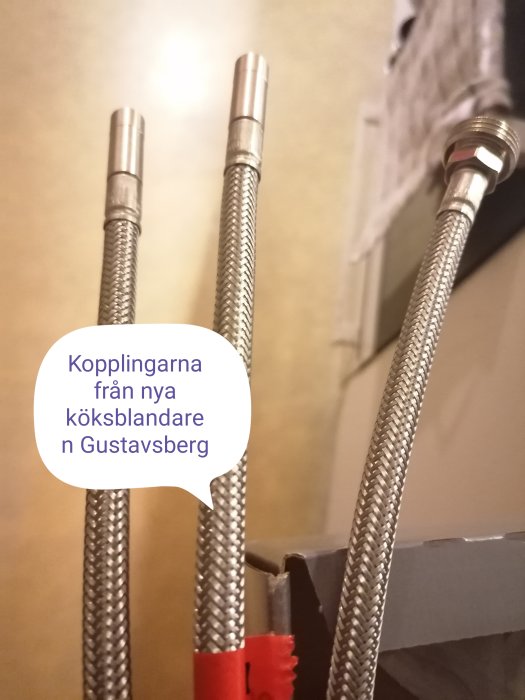 Kopplingsrör från en ny Gustavsberg köksblandare med diskmaskinsavstängning, redo för installation.