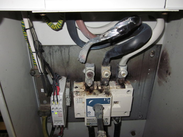 Elektrisk anläggning med säkerhetsbrytare och brända kablar efter en kortslutning.