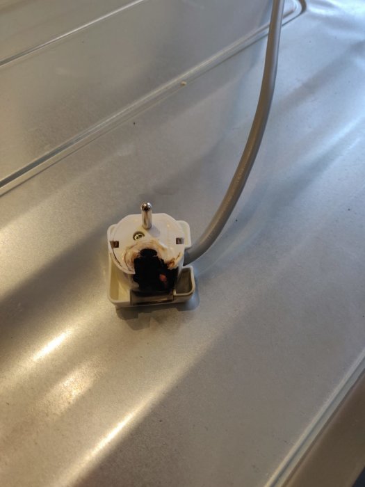 Elkontakt bränd och delvis smält efter långvarig ugnrensning.