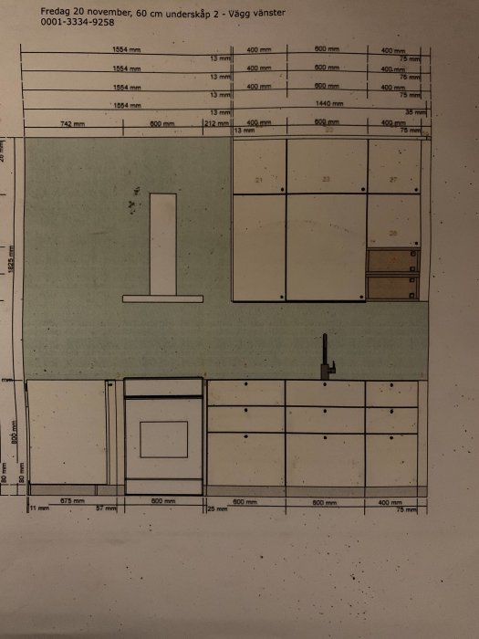 Ritning av ett kök med måttangivelser för skåp och vitvaror, inklusive en grönmarkerad vägg till vänster.