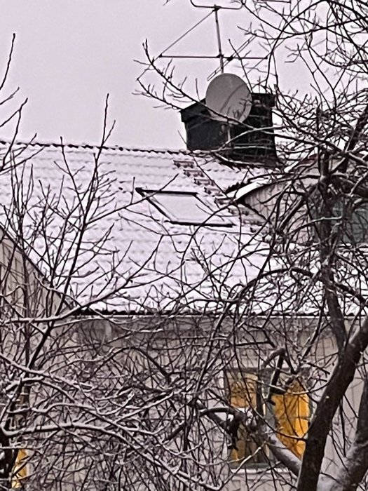 Taktakfönster med omgivande snö och en antenn, området närmast luckan visar tydlig avsaknad av snö.