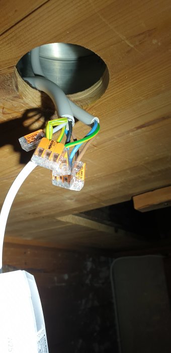 Eluttag med kopplade kablar och WAGO-klämmor i en träbjälke.