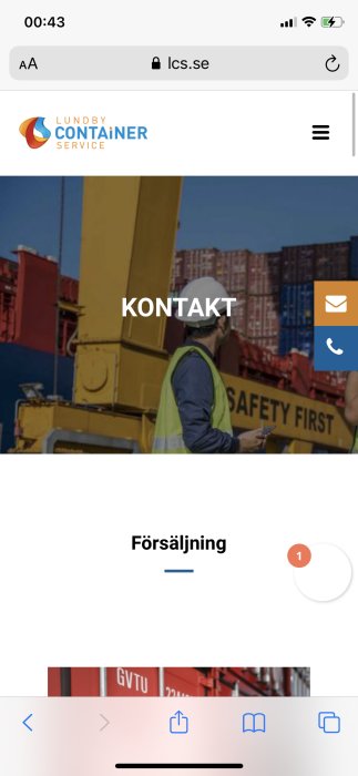 Arbetsman i skyddsväst använder mobil nära staplade fraktcontainrar med texten "SAFETY FIRST".