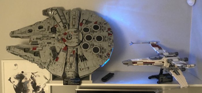 Stor LEGO Millennium Falcon modell bredvid mindre LEGO X-Wing på hylla, båda Star Wars teman.