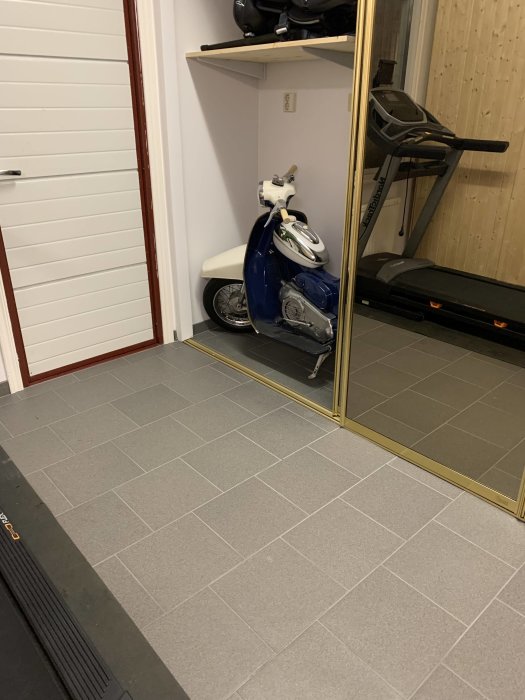 Garage förvandlat till gym med bastu, granitkeramikgolv, spegelvägg och parkerad moped.