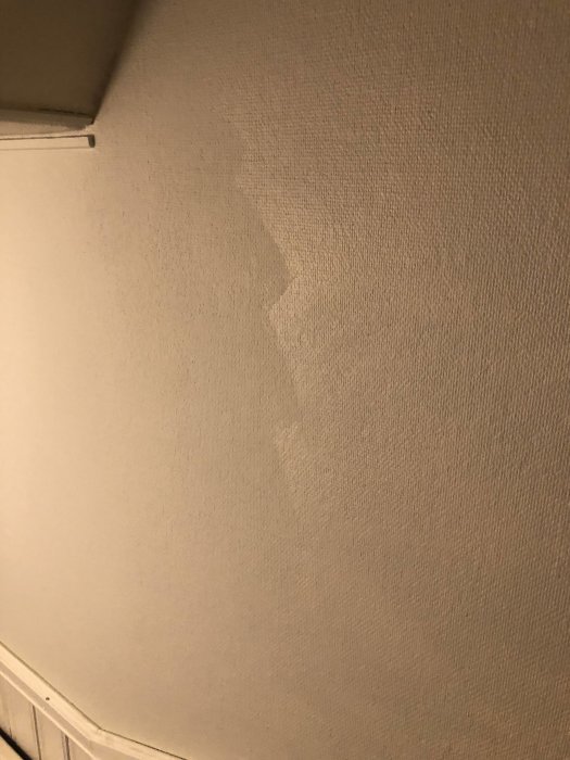 Ojämn väggmålning i trapphus med synlig skillnad i glansgrad och färgnyans.