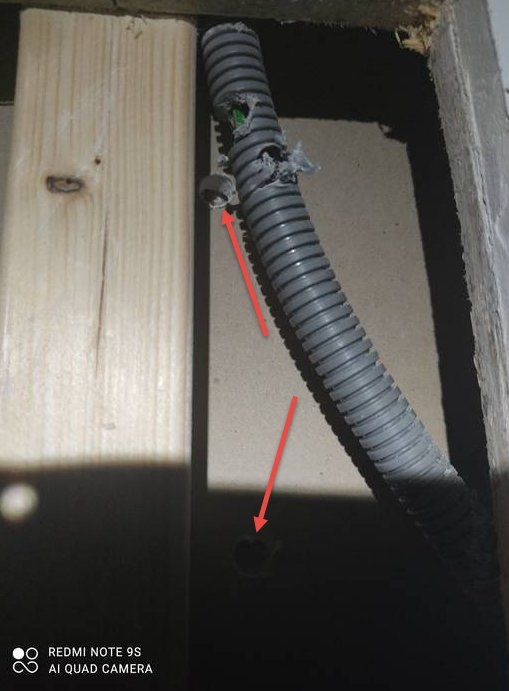 Elrör genomgång med övningsgips markerat med röda pilar i en oavslutad väggkonstruktion.