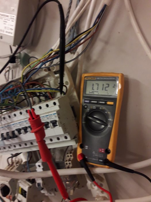 En starkströmsanläggning med öppet kabelarbete och en multimeter som visar 1,71 A på displayen.