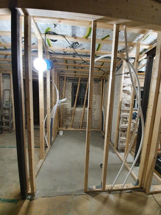 Pågående konstruktion av träreglar i ett utrymme under renovering, avsedda för väggar i ett badrum.