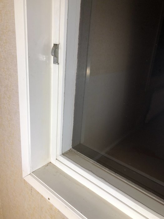 Närbild av ett vitmålat fönster med märket "Fix" på gångjärnet och vibreringsproblem beskrivet i inlägget.
