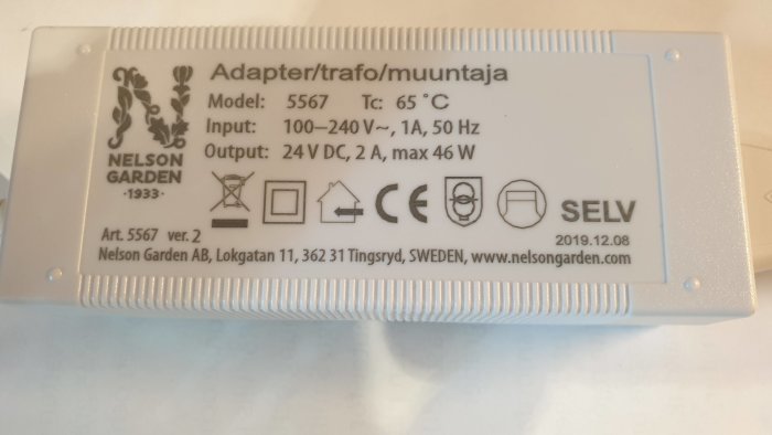 Vit transformator för växtbelysning från Nelson Garden med tekniska specifikationer och säkerhetsikoner på etiketten.