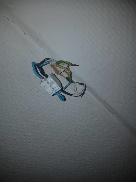 Elektriska sladdar i en oordning kopplade till en temporär sockerbit i ett tak.