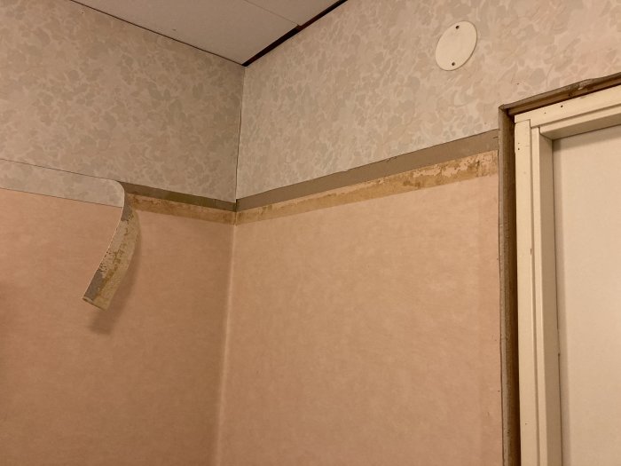 Ett gammalt badrum med plastmatta på väggar, bård skuren och förberett för kakling.