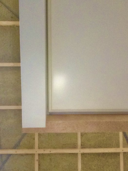 Nyinstallation av ytterdörr med tröskel ovanpå golvnivån och golvreglar synliga nedanför.