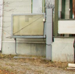 Utomhus rullstolshiss bredvid en byggnad, ej fast monterad i fasaden.