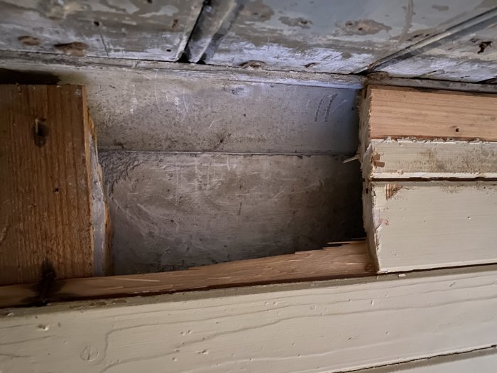 Avlägsnat hörn av pärlspont i ett tak som avslöjar en äldre putsyta under i ett renoveringsprojekt.