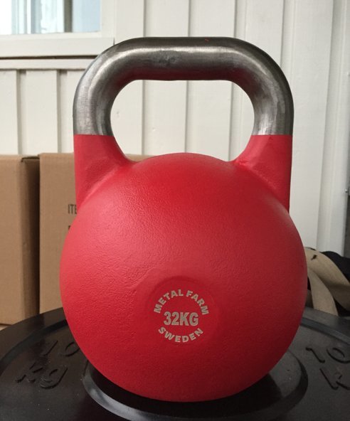 Röd 32 kg kettlebell med silverhandtag och inskrift "METAL FARM SWEDEN" på svart viktplatta.