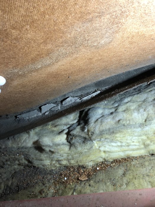 Bild på vindpapp som släppt med synligt grus och frökapslar på isolering i en vind.