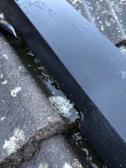 Närbild på takpanna och plåtarbete med synlig överlappning och fukt på hus från 70-talet.