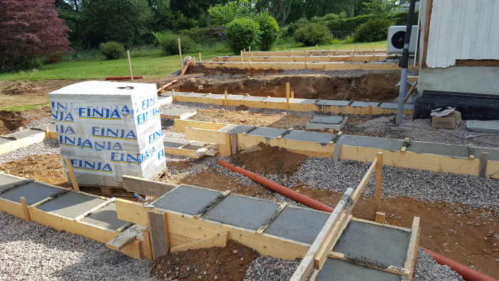 Formar för fundament med betong och armeringsjärn i ett markarbetsstadium för husrenovering.