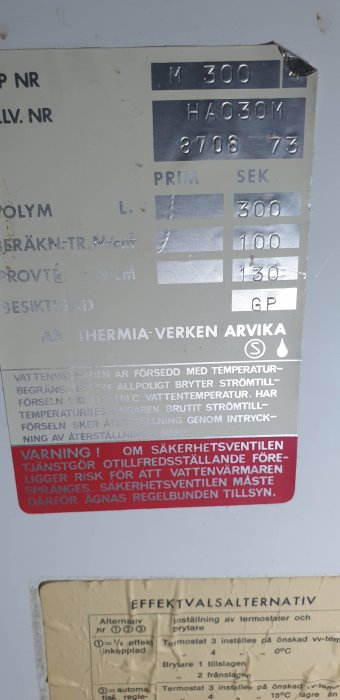 Närbild på etikett av värmepump märkt 'Thermia-Verken Arvika', visar teknisk information och varningar.