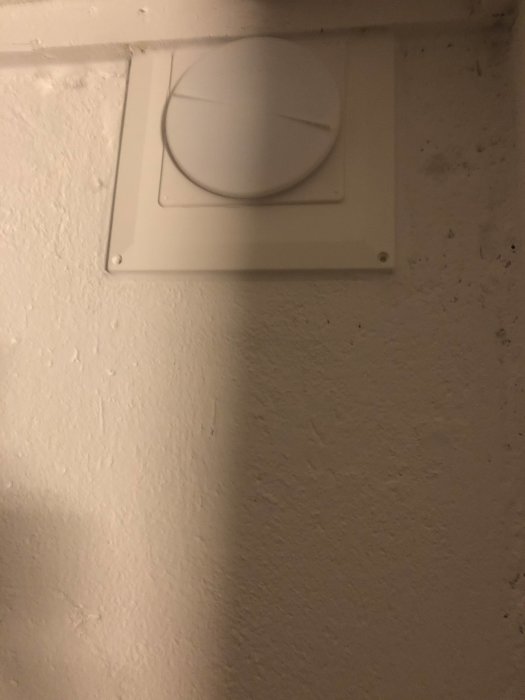 Renoverad ventilation med täckplatta och talriksventil på en vägg.