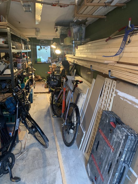 Ett organiserat garage med cyklar och trämaterial placerade på konsoler längs väggen för att undvika trassel.