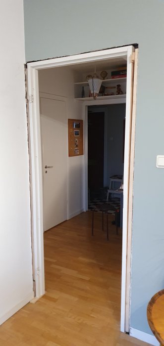 Nyinstallerad vit dörröppning utan lister med synlig skruvning och limrester.
