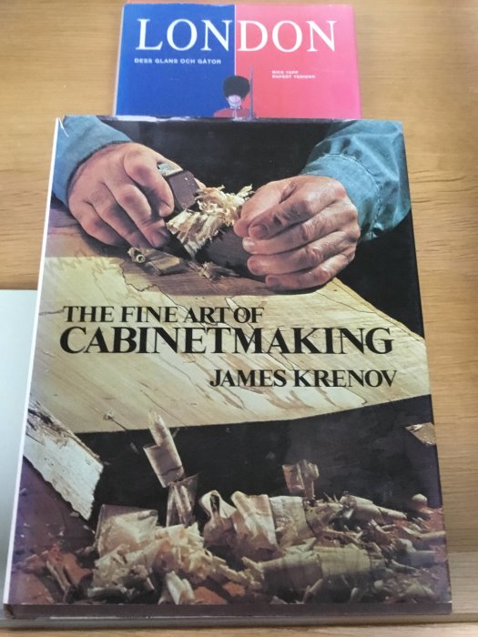 Ett exemplar av boken "The Fine Art of Cabinetmaking" av James Krenov framför en bok om London.