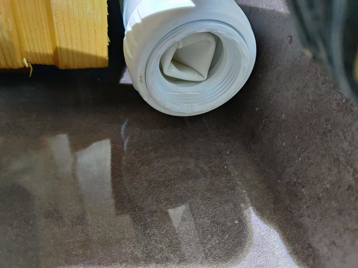Plaströr med öppnat inspektionsöppning som visar ett inre plastfilter mot en mörk bakgrund.