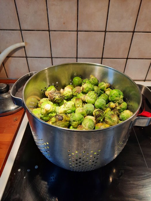 En kastrull full med brysselkål på ett köksspishäll.