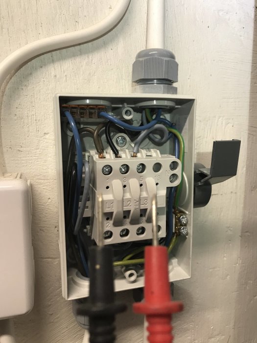 Öppet elsäkerhetsbrytarskåp med synliga kablar och terminaler, indikerar potentiellt problem med en säkring.
