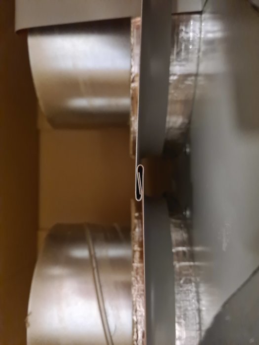 En suddig bild av vad som verkar vara ett rör eller ventilationskanal fixerat med hjälp av en gem.