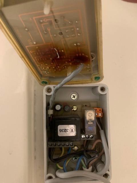 Öppen elektrisk IP 54 kapsling som visar en äldre Termonic termostat och kopplade kablar.