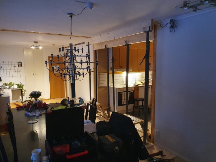Renoveringsarbete i kök med verktyg och material synliga, öppen vägg och takbelysning.