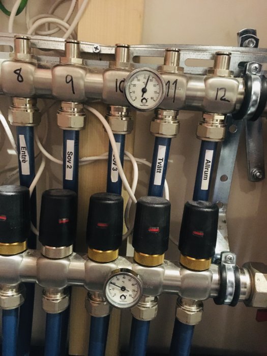 Rörinstallation med termometer och flera markerade rör kopplade till ventiler.
